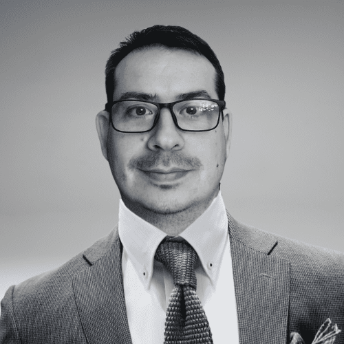 Porträtfoto von Jesús López, dem SEO der Website meinsteuer.de. Er ist ein Mann mit kurzem dunklem Haar, Brille und einem leichten Lächeln. Er trägt einen Anzug mit Krawatte und ein Hemd mit Kragenverstärkung. Das Bild ist in Schwarz-Weiß gehalten und hat einen neutralen Hintergrund.